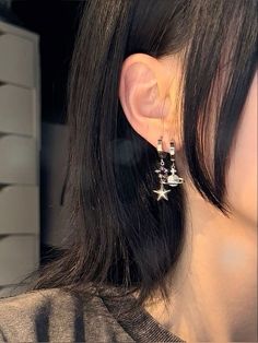 a close up of a person's ear wearing some kind of star shaped earrings