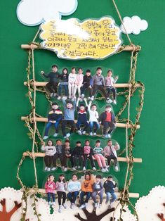 a group of people sitting on top of a wooden sled hanging from the side of a green wall