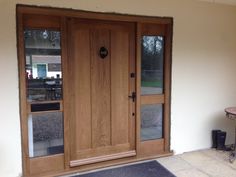 a wooden front door with glass panels