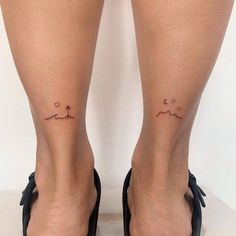 a woman's legs with small tattoos on them