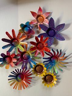 a group of colorful metal flowers on a white wall