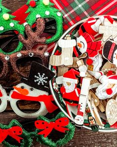 a bowl filled with assorted holiday items on top of a wooden table next to a pair of eyeglasses