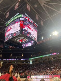 a basketball game is being played in a large arena with people sitting on the sidelines