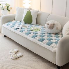 a white couch sitting in a living room next to a window