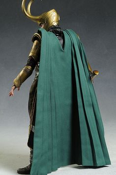 the action figure is wearing a green cape and gold helmet with horns on his head