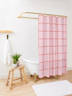 a bathroom with a pink shower curtain next to a white bath tub and wooden stool