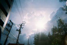 the sun shines brightly behind power lines