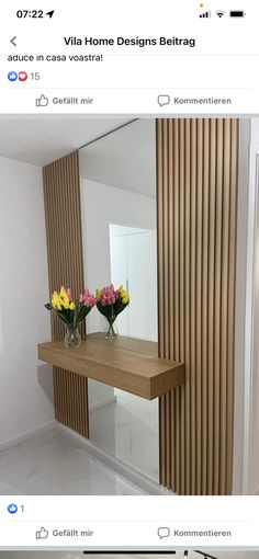 two vases filled with flowers sit on a wooden table in front of a mirror