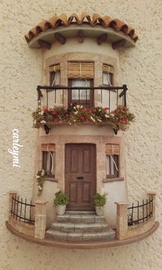 a doll house with flowers on the balcony and balconies over the front door