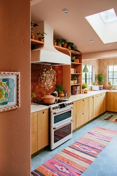 a kitchen with an oven, sink, and rug in front of the stove top