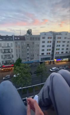 the person is sitting on top of a balcony with their feet up in the air