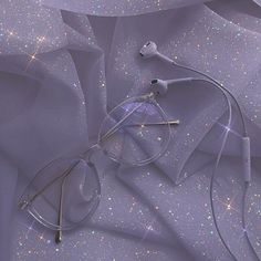 a pair of glasses sitting on top of a purple cloth covered in stars and sparkles