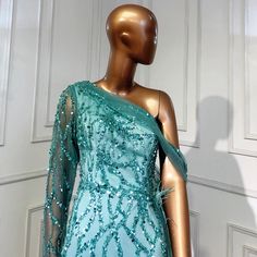 Mesmerizing Turquoise Hue: Radiates vibrance and charm, perfect for making a statement. Mermaid Silhouette: Accentuates curves gracefully, offering a flattering fit. Overskirt Detail: Adds drama and flair to the gown, creating an eye-catching look. Luxurious Beaded Embellishments: Enhances the gown's elegance and adds a touch of sparkle. High-Quality Craftsmanship: Expertly crafted for comfort, durability, and a flawless finish. Versatile Wear: Suitable for various occasions, including weddings, galas, and formal parties. 2022 Collection: Stay ahead of fashion trends with this contemporary evening gown. Attention to Detail: Every aspect of this gown is meticulously designed for a sophisticated appearance. Glamorous Green Mermaid Gown, Green Mermaid Gown For Party, Green Mermaid Evening Gown, Embellished Green Mermaid Dress For Evening, Embellished Green Gown For Pageant, Green Embellished Gown For Pageant, Embellished Green Gown For Pageants, Embellished Mermaid Gown For Gala, Embellished Green Floor-length Mermaid Dress