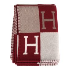 two red and white towels with the letter h on it's front, sitting next to each other