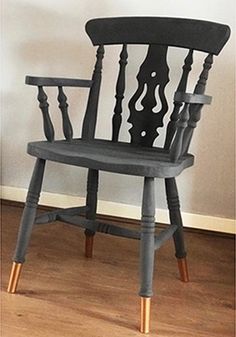 a wooden chair sitting on top of a hard wood floor next to a white wall