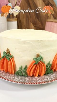 a cake with frosting and pumpkins on it sitting on top of a plate