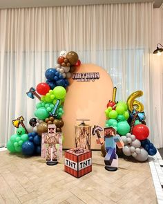 an assortment of balloons and decorations in front of a stage set up for a party