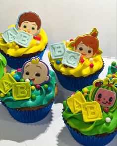 four cupcakes decorated to look like children's abc and j are sitting on top of each other