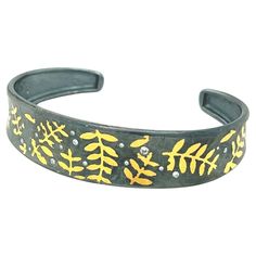 a black bracelet with yellow leaves on it