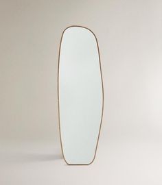 an oval shaped mirror sitting on top of a table