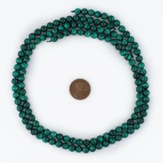 two strands of green glass beads with a penny