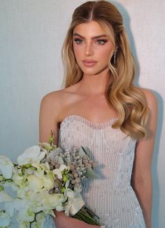 a beautiful woman holding a bouquet of flowers