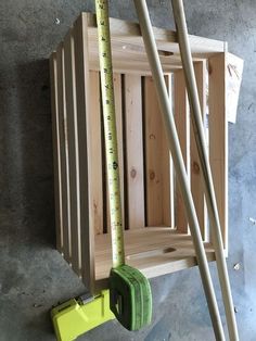 some tools are laying on the floor next to a wooden box and measuring rulers