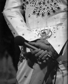 an old photo of a man in elvis garb holding his hands out to the side