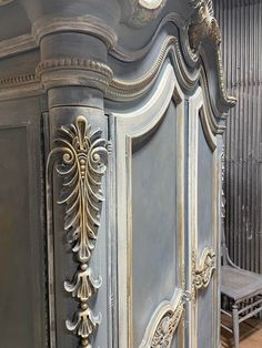 an ornate armoire in grey and gold