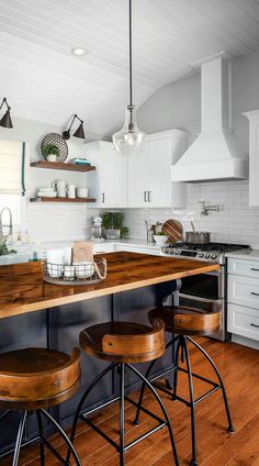 a kitchen with two stools and an island in front of the stove top oven