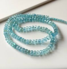 two strands of blue glass beads on a white surface