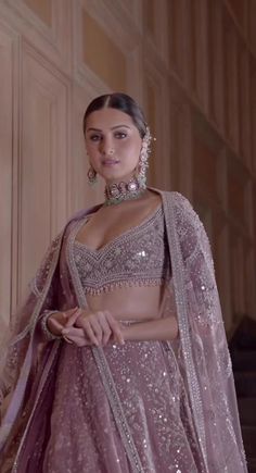 a woman in a pink lehenga with silver jewelry on her neck and shoulders