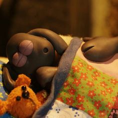 a stuffed animal laying on top of a blanket