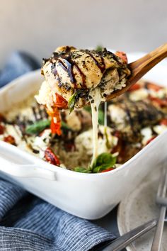 a spoonful of chicken and rice casserole being lifted from a white dish