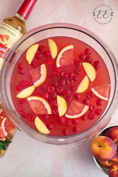 a bowl filled with fruit and ice on top of a yellow table next to other fruits