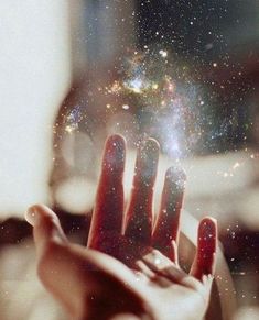 a person's hand reaching out towards the stars