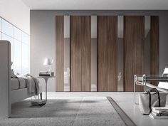 a living room filled with furniture next to a wall mounted book shelf and sliding doors