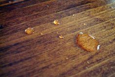 a piece of food that is on top of a wooden table with water droplets all over it