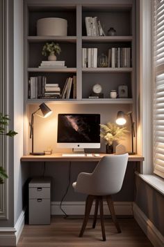 a desk with a computer on top of it in front of a bookshelf