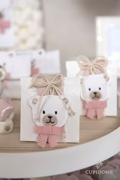 two small teddy bears with bows on their heads are sitting in front of some cards