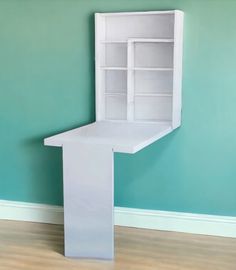 an empty white shelf in the corner of a room with blue walls and hardwood floors