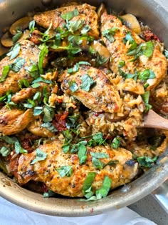 a pan filled with chicken and vegetables on top of a table