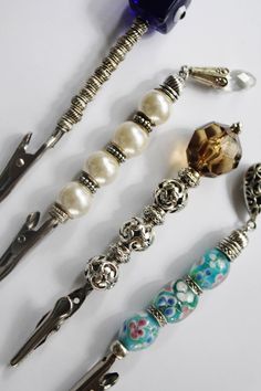 four different types of bead and charm bracelets on a white surface with beads