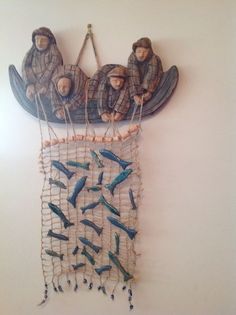 a group of people hanging from the side of a wall next to a net with birds on it