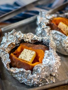 baked sweet potatoes with butter and seasoning in tin foil