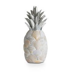 a white ceramic pineapple with shells on it