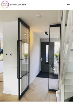 the interior of a house with glass doors and stairs leading up to the second floor