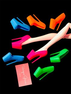 there are many different colored plastic objects on the black surface, including one doll's legs