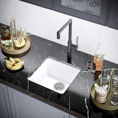 a white sink sitting on top of a black counter