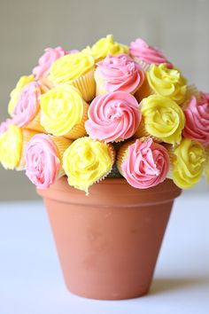 cupcakes in a flower pot with pink and yellow frosting